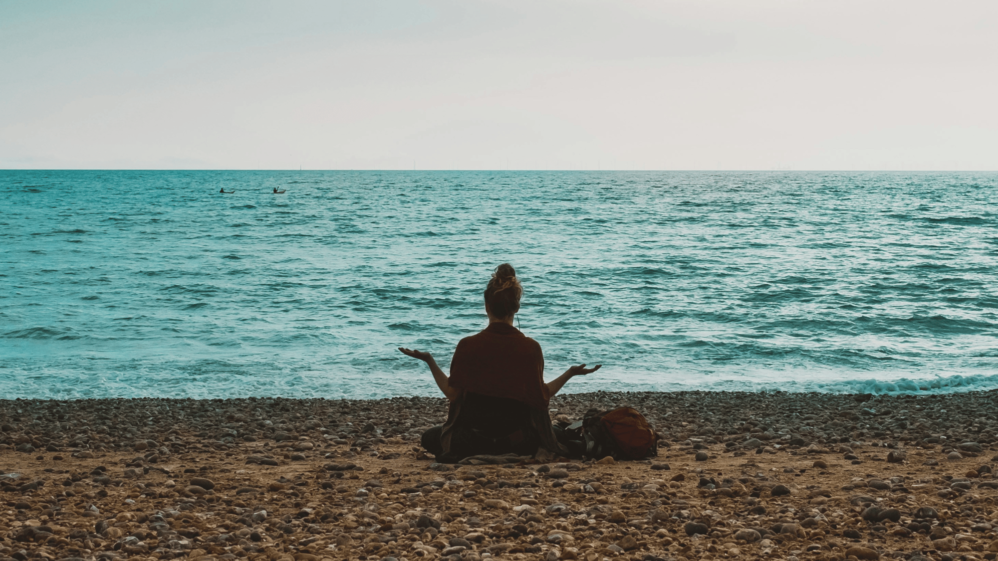 Yogui sentado en la playa a primera hora de la mañana