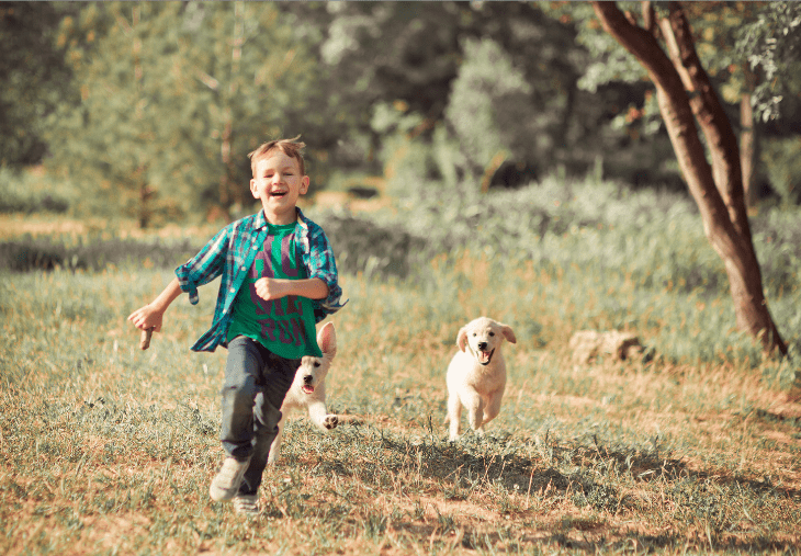 niño corriendo al aire libre con cachorro
