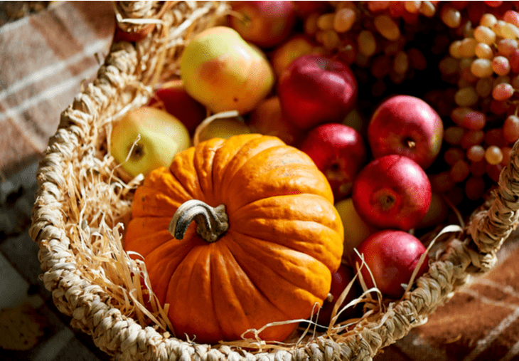 Cesta de otoño con manzanas y calabazas